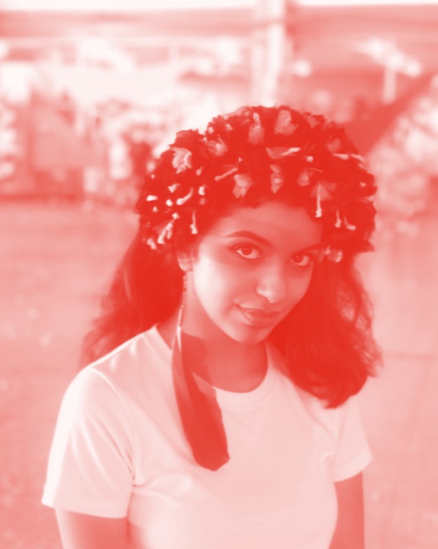 Red-toned portrait of Isabela Açu wearing a feather headdress.